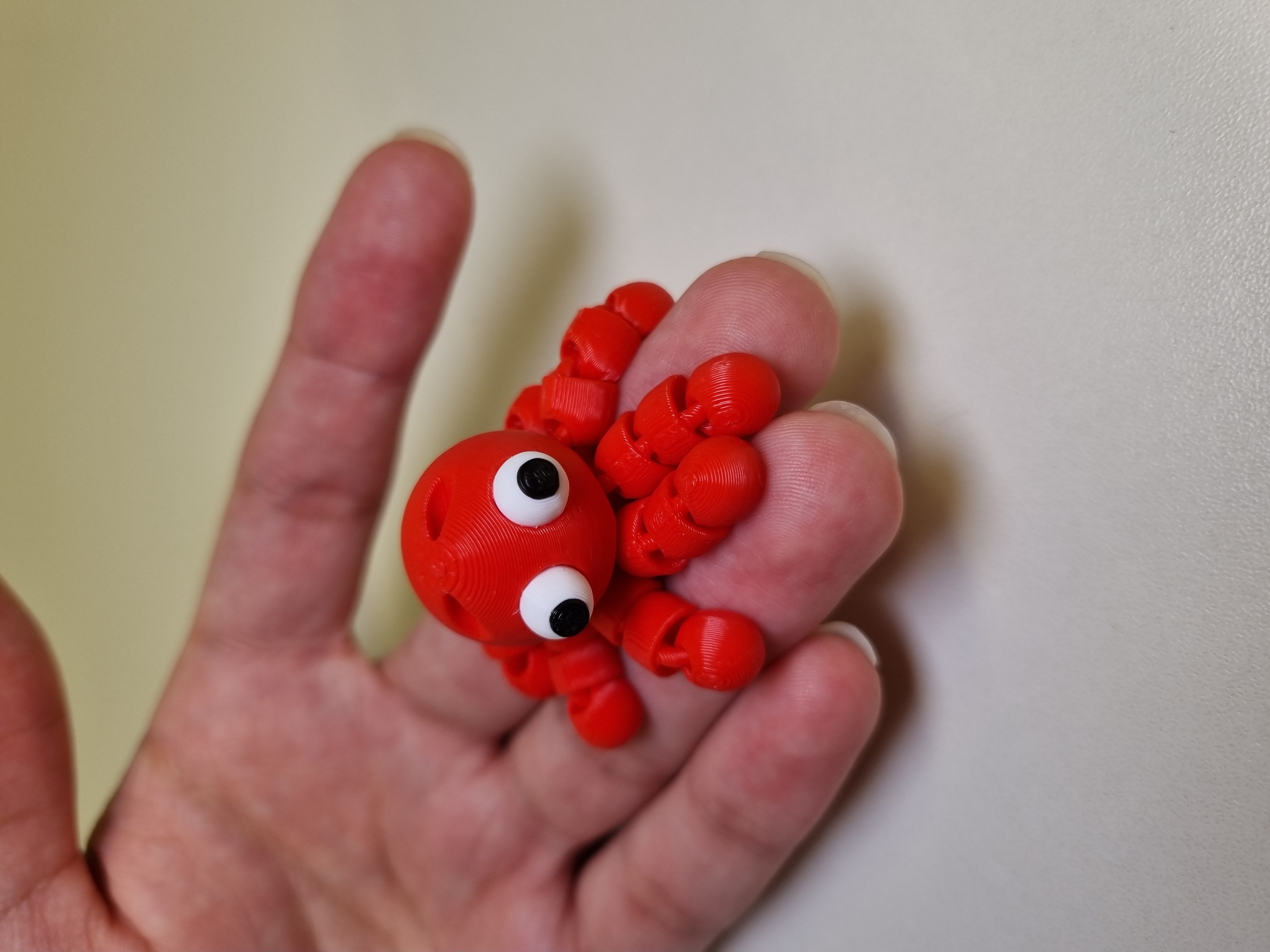 Polvo articulado vermelho na palma da mão